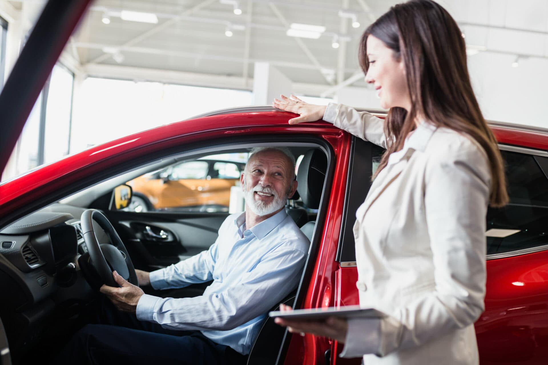 Saleswoman at the dealers discussing a family car