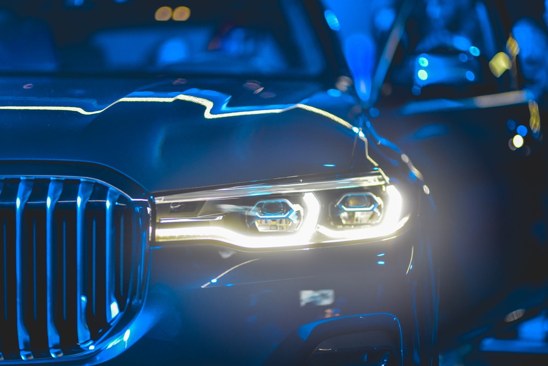 Close up view of luxury blue car's headlight at night